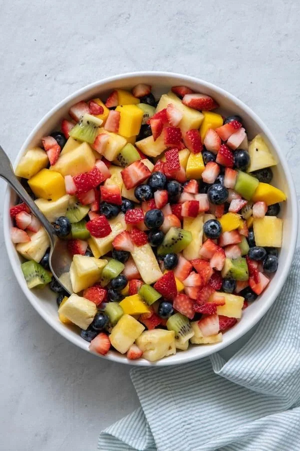 A colorful bowl of fresh fruit salad featuring a variety of fruits.
