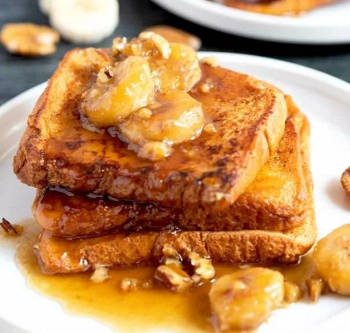 Delicious Bananas Foster French Toast drizzled with caramel sauce and topped with bananas