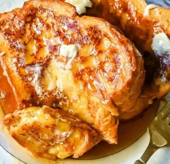 Delicious plate of the best French toast topped with syrup and fresh berries.