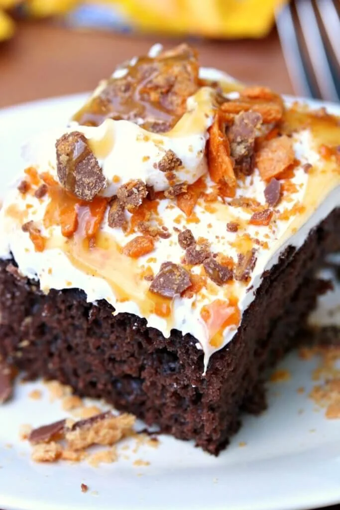 Delicious Butterfinger Bomb Cake with chocolate layers and Butterfinger topping