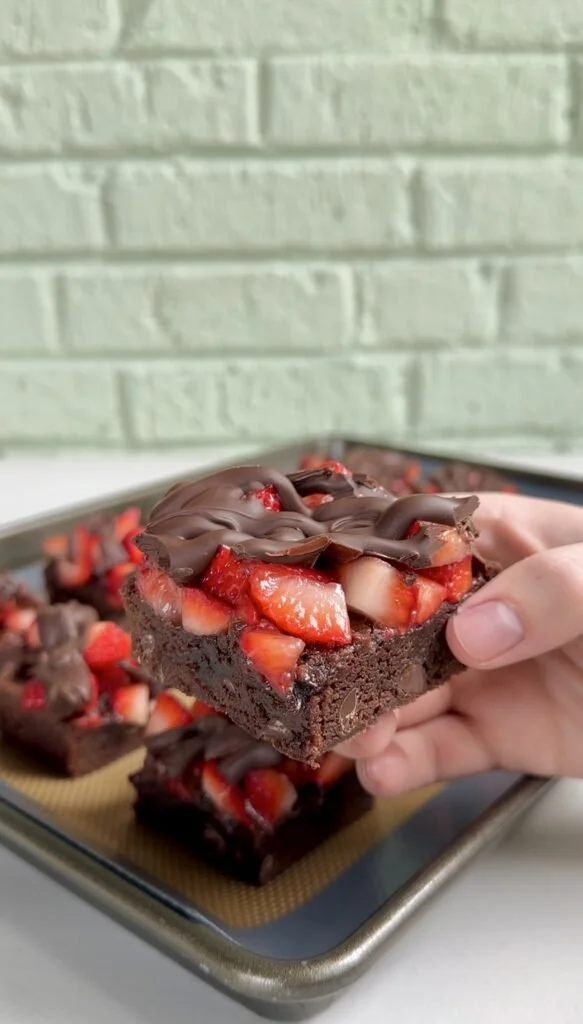 Delicious chocolate covered strawberry brownies topped with fresh strawberries