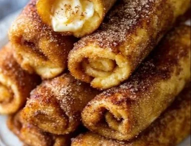 Cinnamon Sugar French Toast Roll-Ups served with syrup and powdered sugar