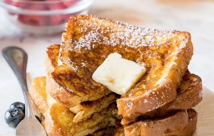 Classic French toast served with syrup and berries on a breakfast plate