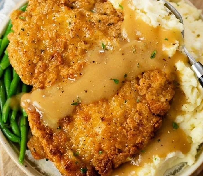 Delicious country fried chicken breast served with sides