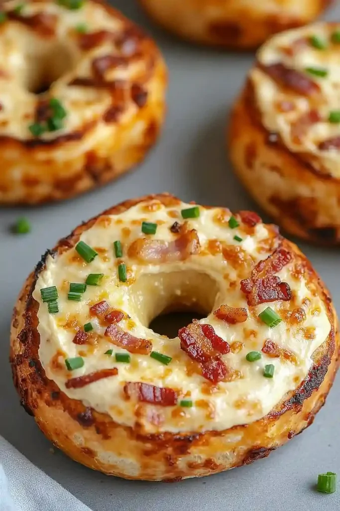 Creamy bacon cheddar bagels fresh out of the oven, topped with melted cheese and crispy bacon.