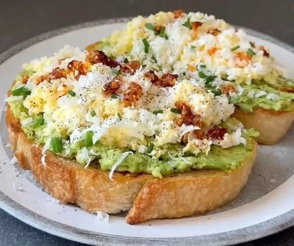Grated Egg Avocado Toast topped with spices and herbs for a healthy breakfast.