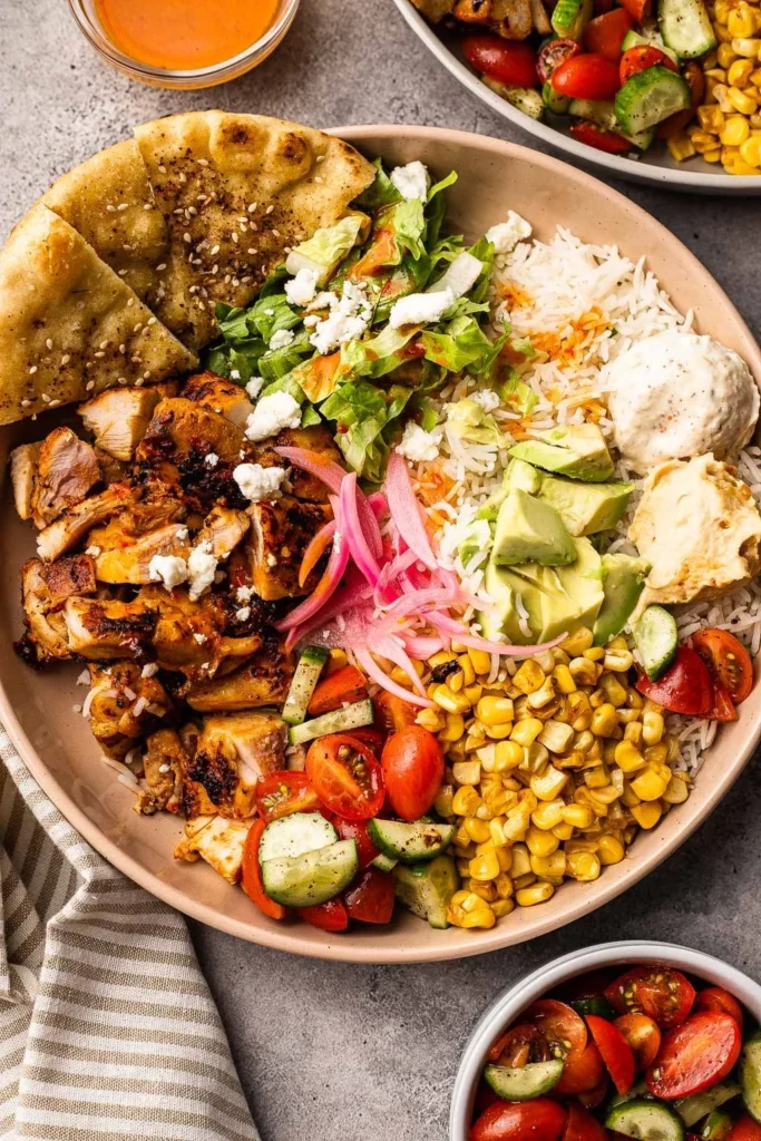 Delicious Harissa Chicken Bowl topped with fresh vegetables and herbs