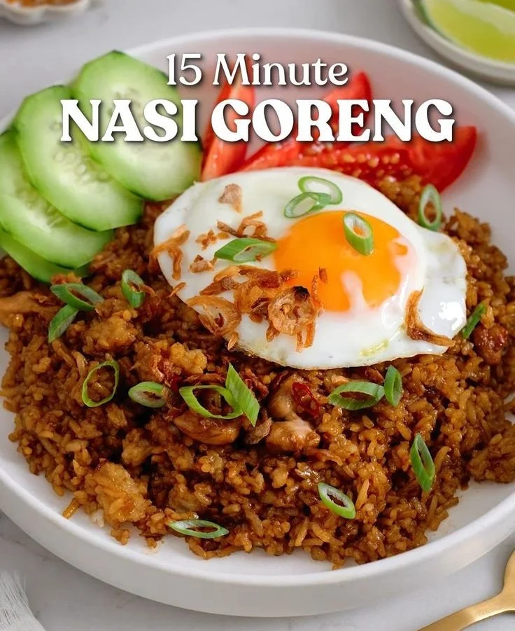 Plate of delicious Indonesian Fried Rice garnished with vegetables and fried egg