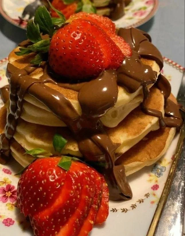 Delicious Japanese soufflé pancakes stacked high with syrup and fruit garnish