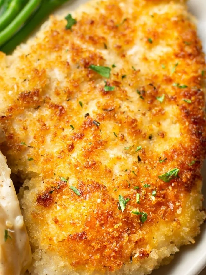 Delicious Parmesan Crusted Chicken garnished with herbs and served on a plate