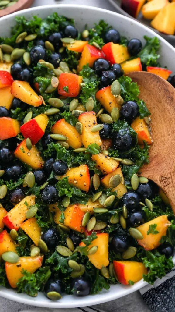 A vibrant Peach Blueberry Kale Salad with fresh fruits and leafy greens