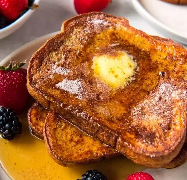 Deliciously cooked Perfect French Toast on a plate with syrup and berries