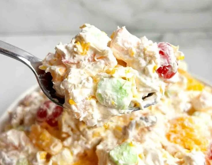 Bowl of Ambrosia Fruit Salad filled with mixed fruits and creamy dressing