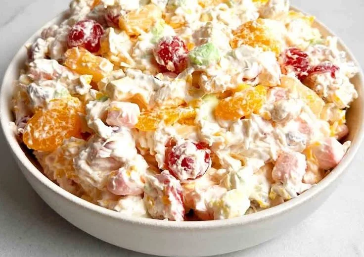 Delicious Ambrosia Salad served in a bowl with colorful fruits and whipped topping