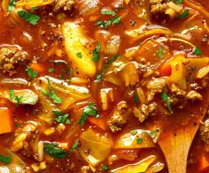 Delicious homemade cabbage roll soup in a bowl with fresh herbs on top