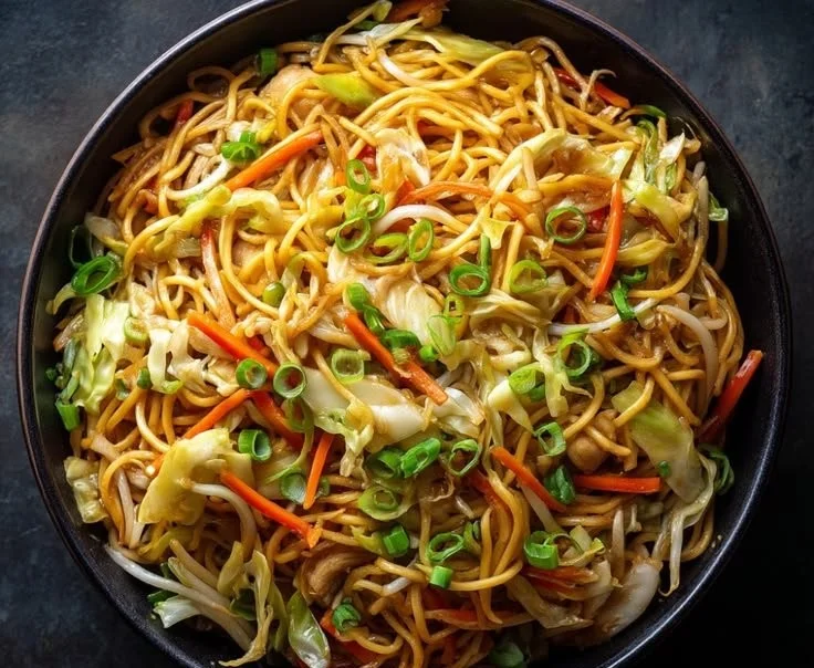 Delicious homemade Chow Mein dish, better than takeout, garnished with greens.