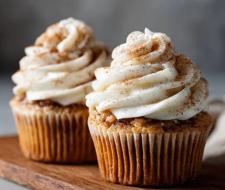 Freshly baked cinnamon roll cupcakes with creamy frosting and cinnamon swirl