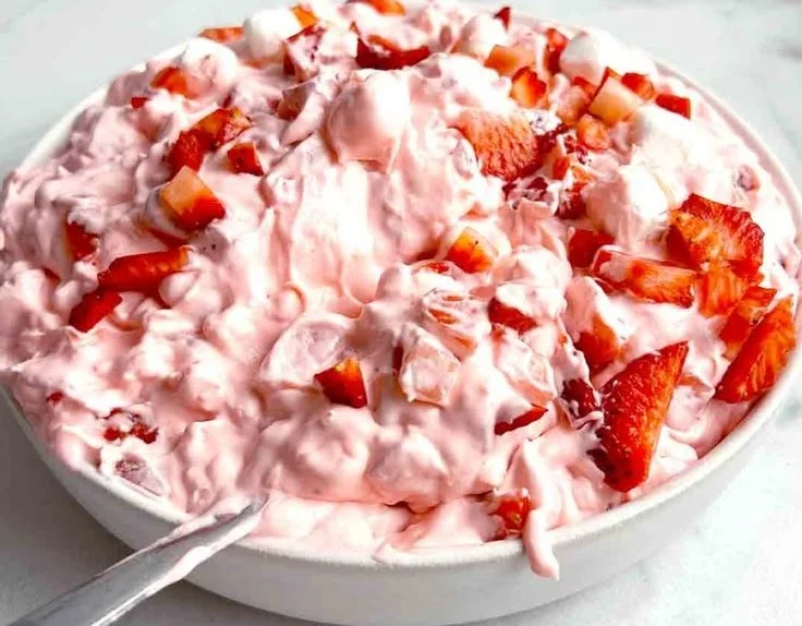 Delicious Cool Whip Strawberry Fluff Salad in a bowl garnished with fresh strawberries