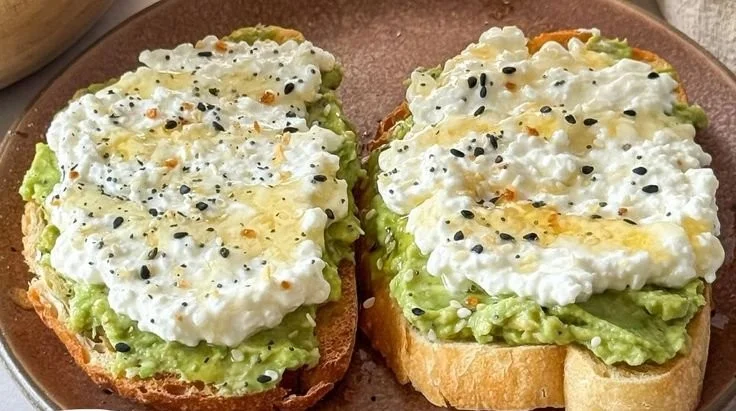 Cottage cheese avocado toast topped with fresh herbs and cherry tomatoes