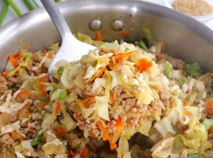 Delicious homemade egg roll in a bowl with fresh vegetables and savory sauce.