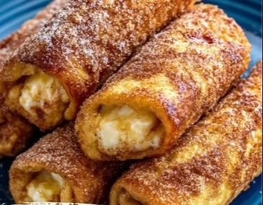 French Toast Roll-Ups dusted with cinnamon sugar on a plate