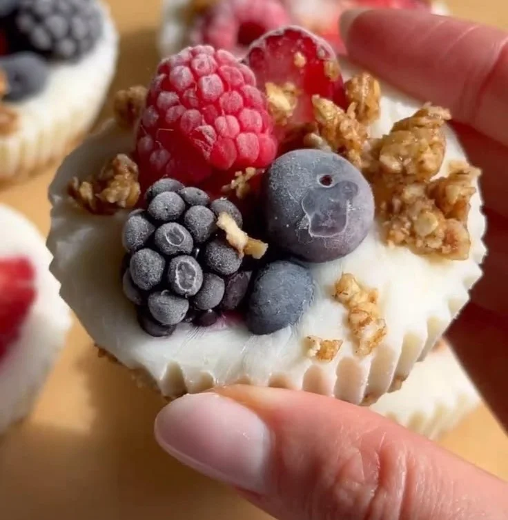 Colorful frozen yogurt cups topped with fresh fruits and sprinkles