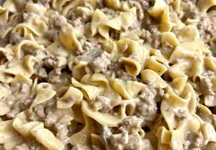 Delicious ground beef stroganoff served with pasta and garnished with parsley.