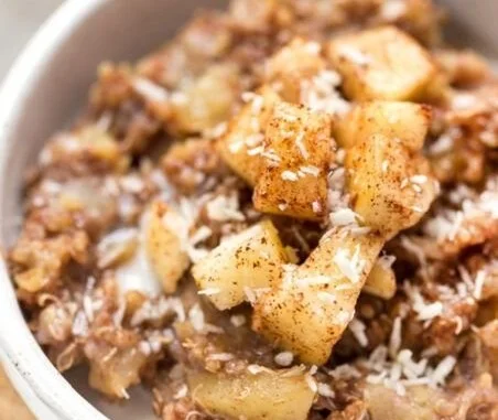 Delicious healthy apple cinnamon quinoa breakfast bowl topped with fresh apples and cinnamon