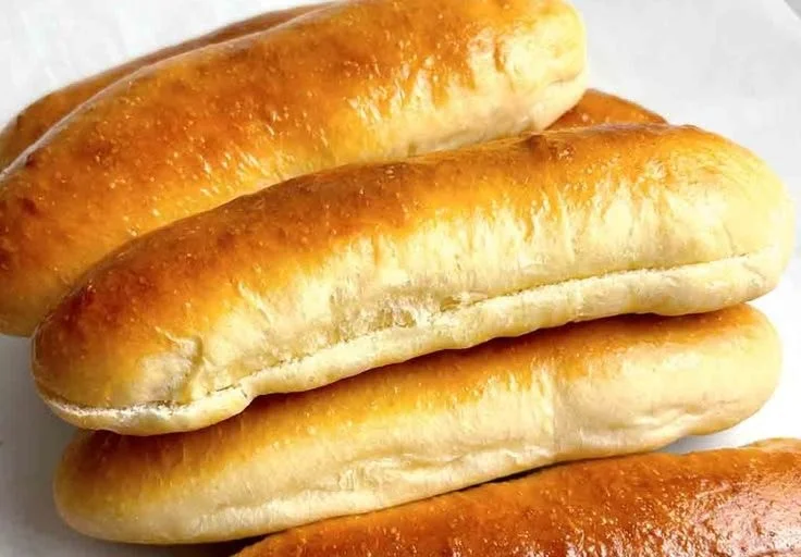 Freshly baked homemade hot dog buns ready for grilling.
