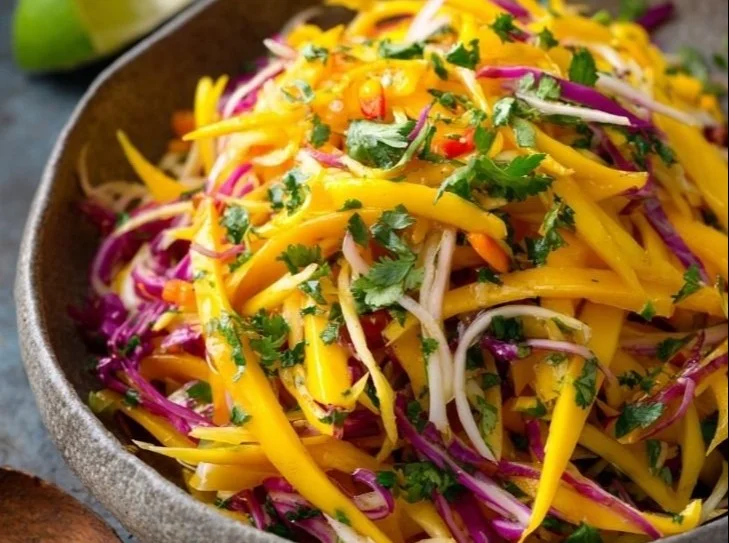 Delicious mango slaw with colorful vegetables in a bowl