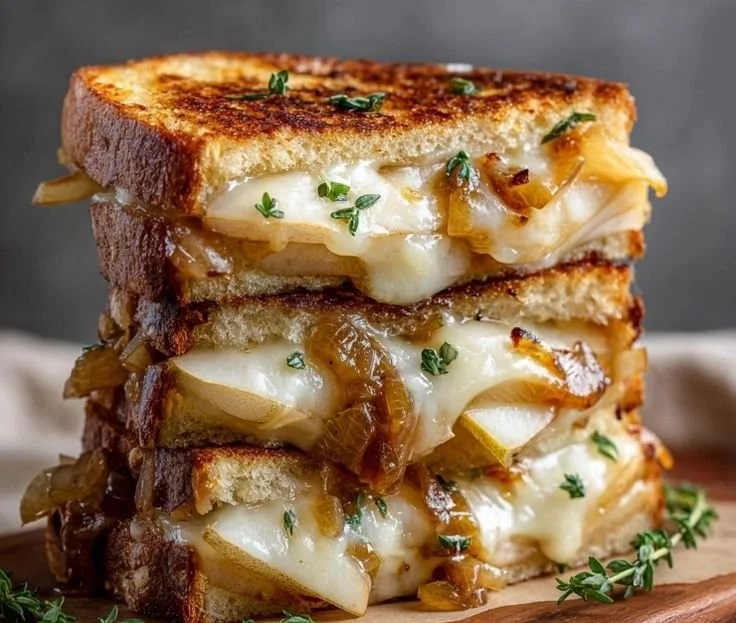 Pear and apple grilled cheese sandwich topped with caramelized onions.