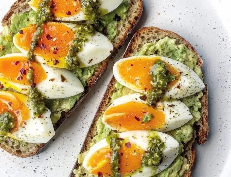 Pesto avocado toast topped with eggs, a nutritious breakfast option