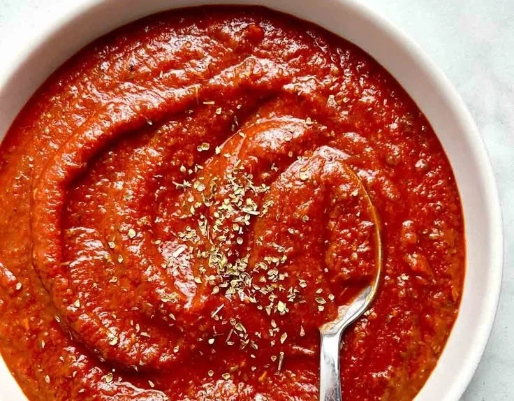 Bowl of quick homemade pizza sauce prepared with fresh ingredients.