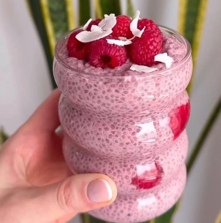 Delicious raspberry chia pudding in a glass with fresh raspberries on top