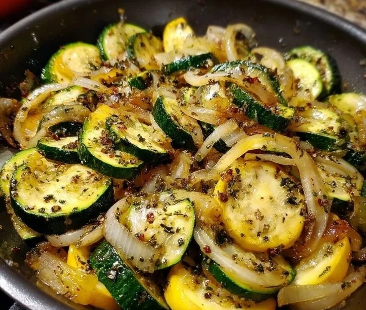 Delicious sautéed zucchini and onions served in a skillet.