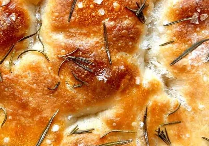 Homemade sourdough discard focaccia bread topped with herbs and olive oil