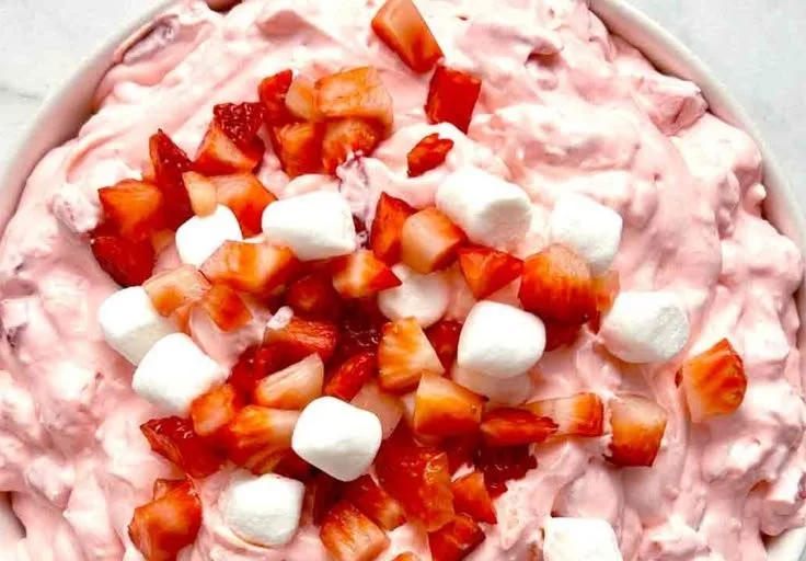 Delicious Strawberry Fluff Salad with whipped cream, marshmallows, and strawberries.