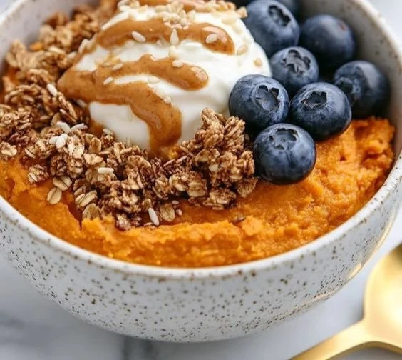 Delicious sweet potato breakfast bowl topped with nuts and berries