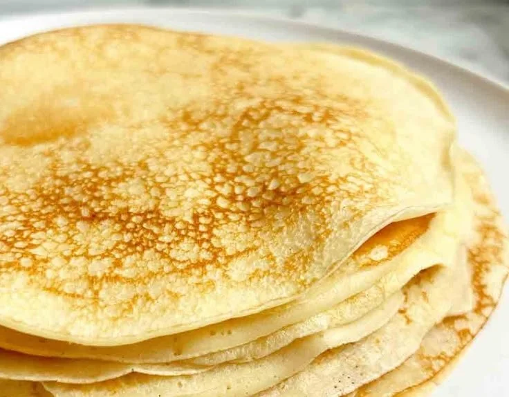 Plate of traditional Swedish pancakes topped with berries and syrup