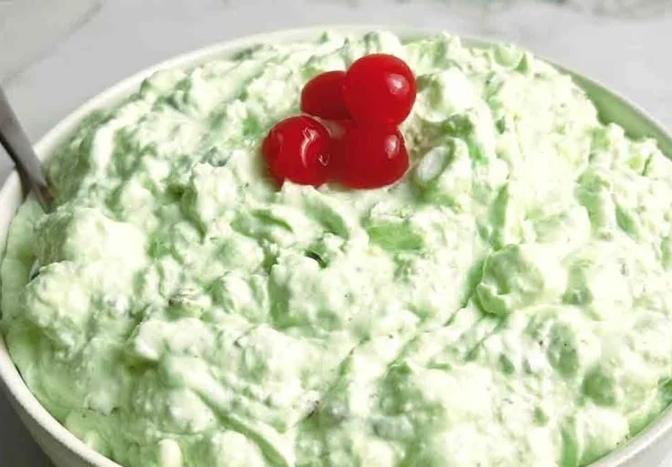 A bowl of Watergate Salad with marshmallows, pineapple, and pistachio.