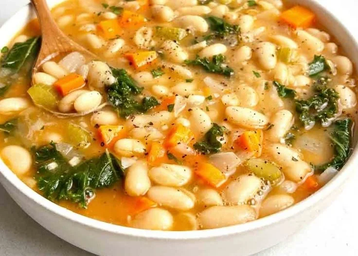 Bowl of delicious homemade white bean soup garnished with herbs