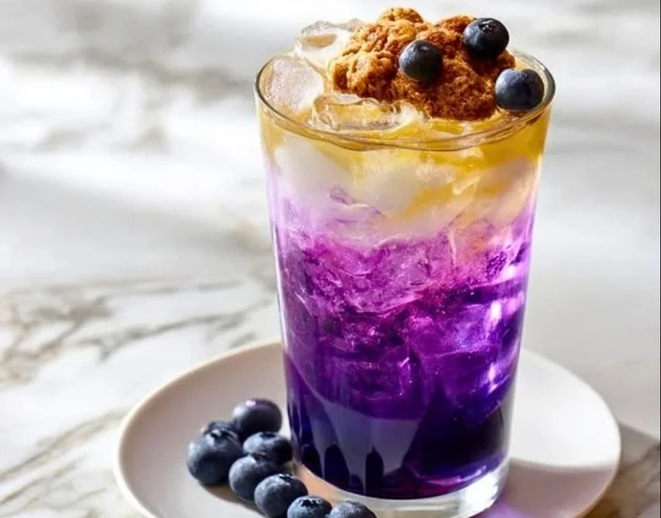 Blueberry Muffin Dirty Soda served in a glass with blueberries and ice