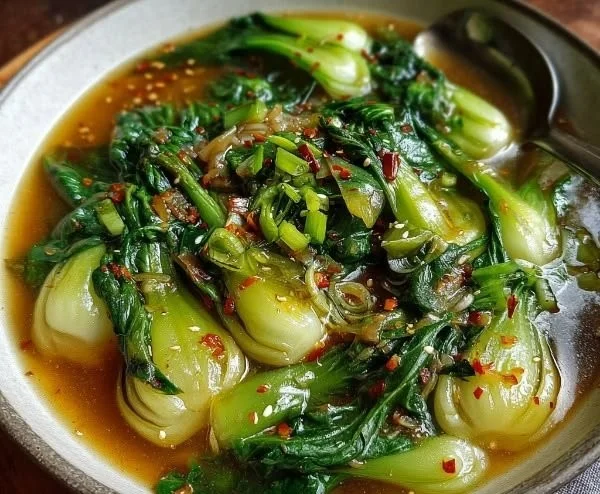Bok Choy Garlic Ginger Soup garnished with fresh herbs in a bowl