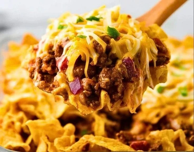 Delicious Frito Pie served in a bowl with toppings like cheese and jalapenos.
