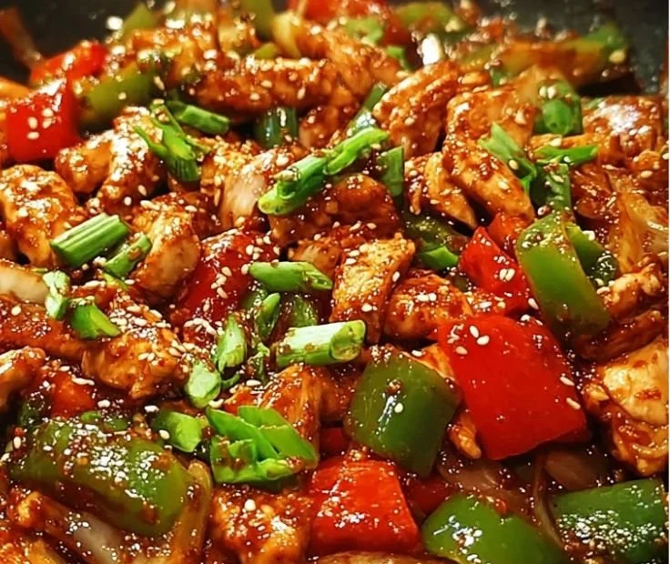 Sizzling Korean spicy chicken stir fry with vegetables in a vibrant sauce.