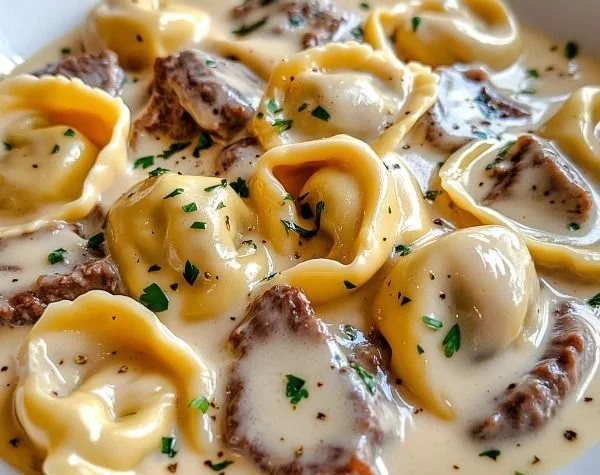 Cheesesteak Tortellini served with creamy provolone sauce in a delicious dish