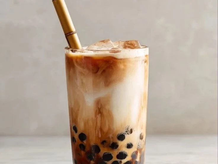A glass of homemade boba milk tea with tapioca pearls and a straw.
