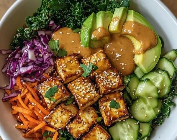 Delicious Tofu Buddha Bowl with Peanut Sauce garnished with fresh vegetables